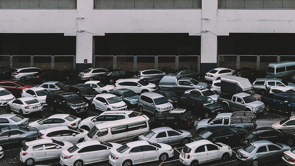 Car park with vehicles parked outside of bays